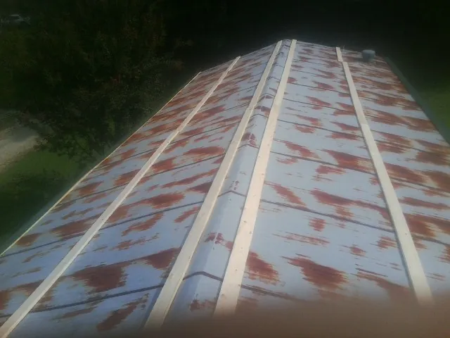 Rusted metal roof panels with new wood purlins before replacement — Storm Damage Roof Repair in Iola by Roofing Brothers